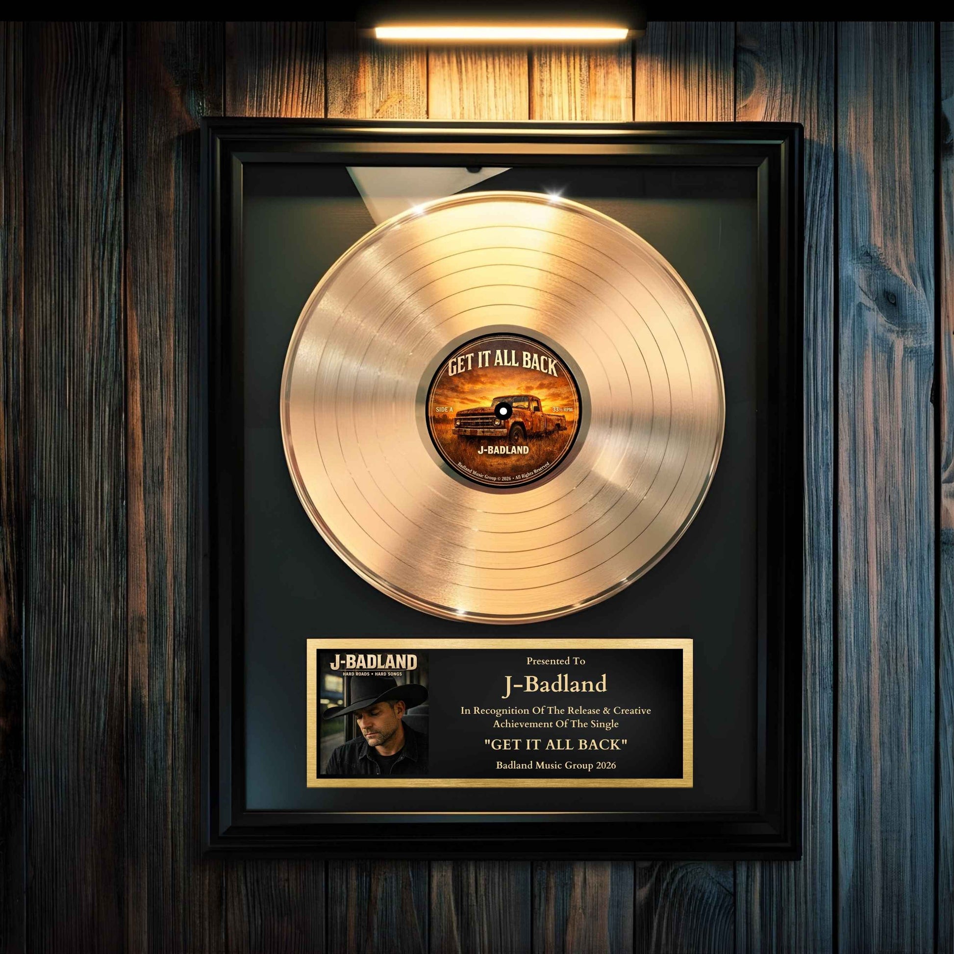 Gold record award hanging on a wall with a led rechargeable picture frame light above it