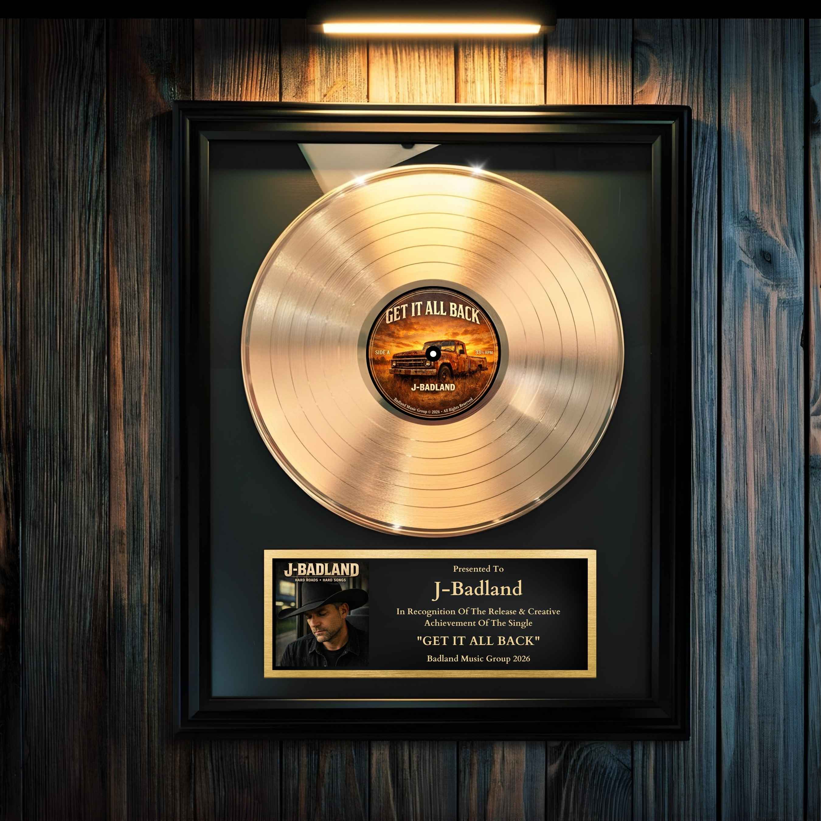 Gold record award hanging on a wall with a led rechargeable picture frame light above it